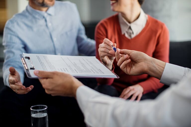 closeup-unrecognizable-couple-signing-contract-with-financial-advisor