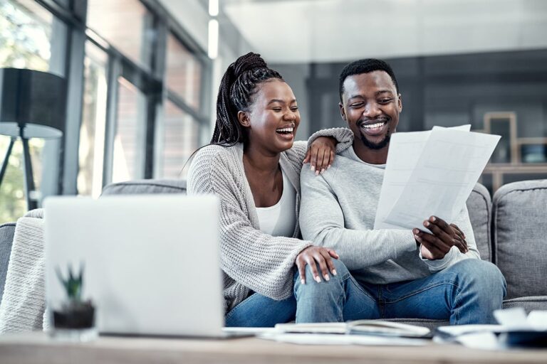 happy-smiling-carefree-black-couple-checking-their-finances-laptop-home-cheerful-husband-wife-excited-about-their-financial-freedom-savings-investment-future-planning